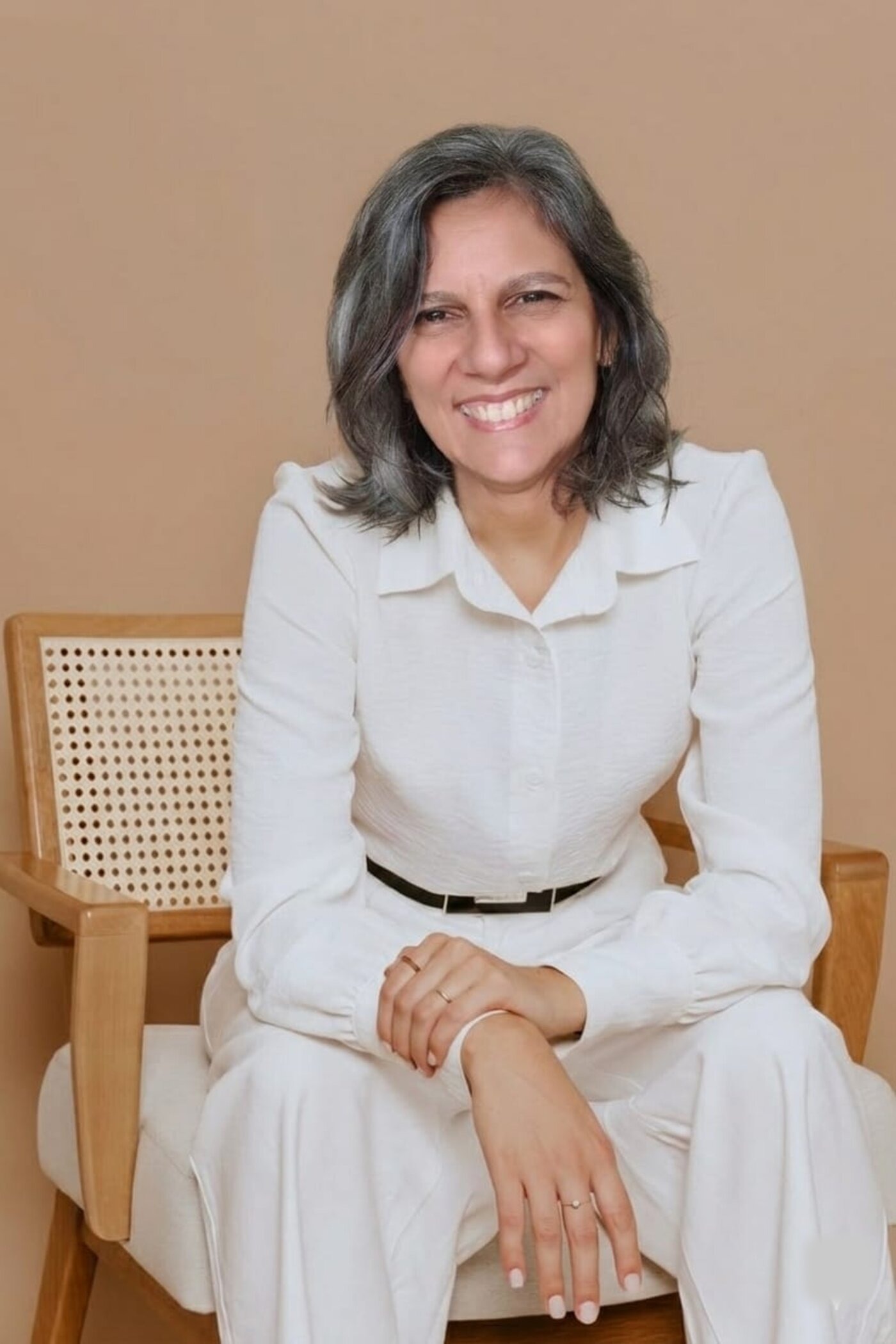 Anna Montteeiro, sorrindo, em ambiente iluminado e acolhedor